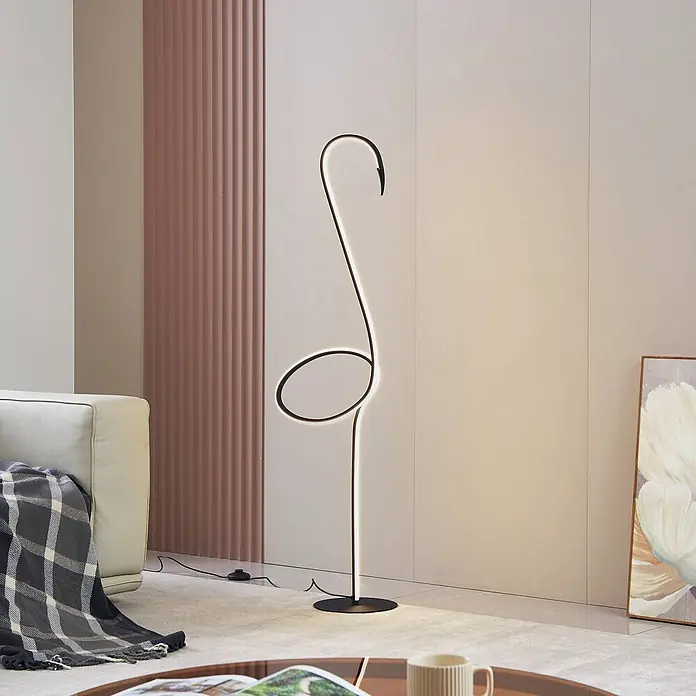 Lindby LED Stehlampe Wohnzimmer in schwarz, dimmbar Stehleuchte -  - Schwarze moderne LED-Stehleuchte in stilisierter S-Form, spendet Umgebungslicht in einem Wohnzimmer neben einem Sofa.