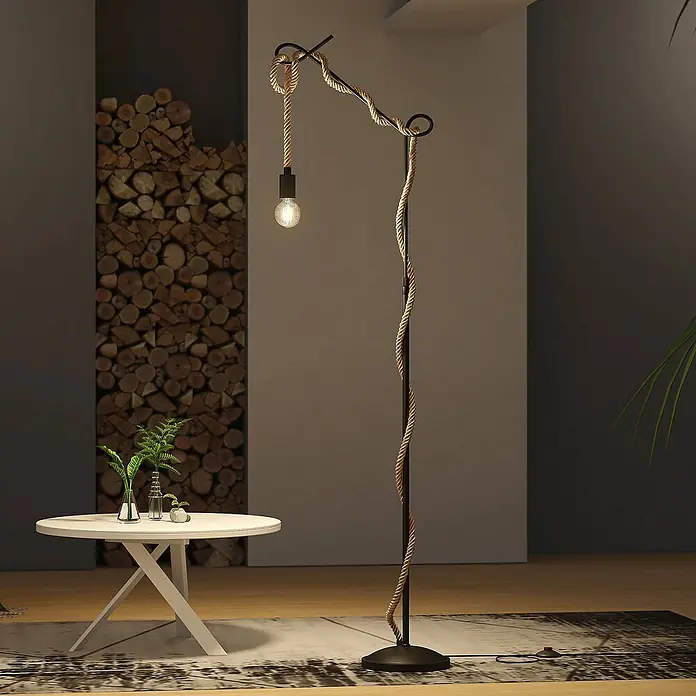 Lucande Stehlampe Wohnzimmer in schwarz, hellbraun, Stehleuchte -  - Eine rustikale Stehlampe mit schwarzem Metallständer und Zierseil, die einen Raum neben einem weißen Tisch beleuchtet.
