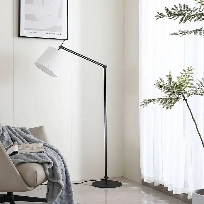 Lucande Stehleuchte Caelia - schwarz, weiß / opal, E27 - Schwarze Metall-Stehlampe mit weißem Faltschirm in einem modernen Wohnraum.