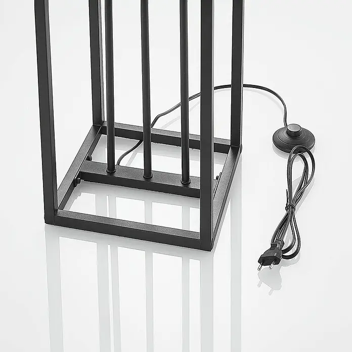Lindby Stehlampe Wohnzimmer in schwarz matt, Stehleuchte -  - Schwarzer Metall-Lampenfuß mit quadratischem Rahmen, Netzkabel, Fußschalter und EU-Stecker auf reflektierender Oberfläche.