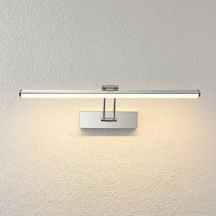 Lindby LED Wandleuchte innen in chrom, weiß, Wandlampe -  - Chrom-beschichtete lineare LED-Bilderleuchte an einer Wand montiert, warmes Licht nach unten strahlend.