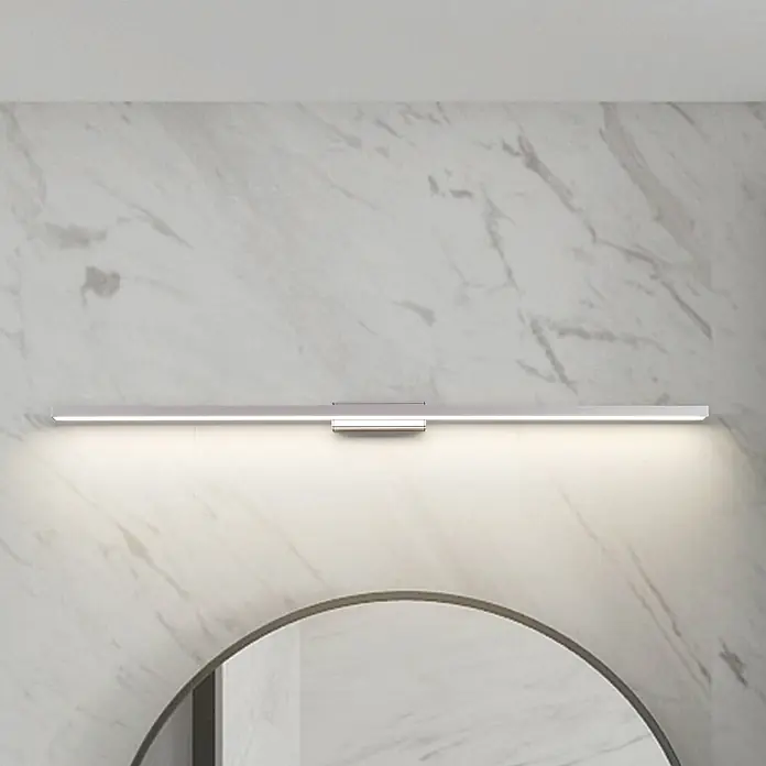 Lindby Wandleuchte Alenia - alu / grau / zink - Lineare LED-Spiegelleuchte aus gebürstetem Metall über einem runden Spiegel an einer Marmorwand, hell leuchtend.