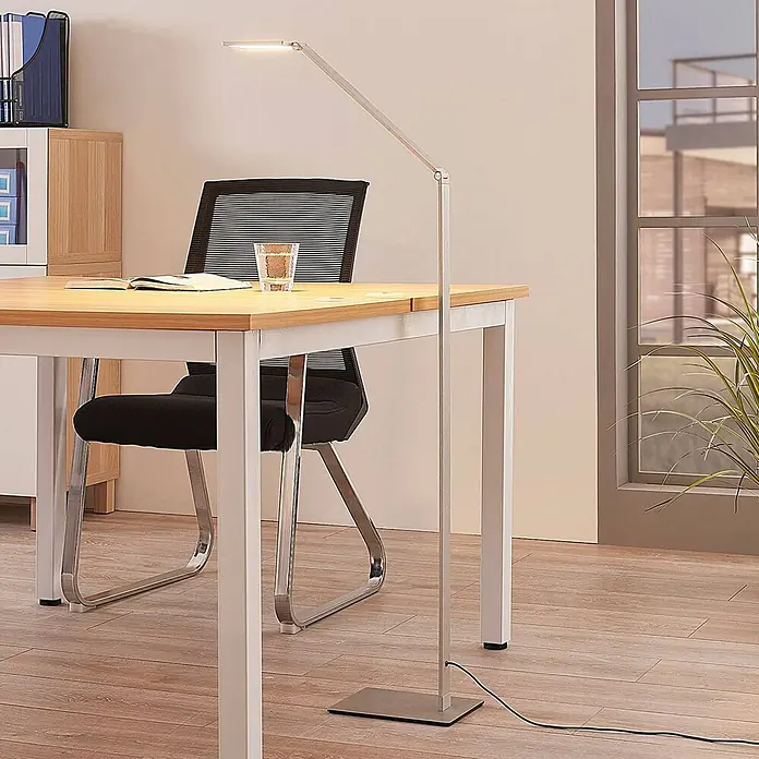 Lucande LED Stehlampe dimmbar, LED Standleuchte, Stehleuchte Arbeitszimmer -  - Verstellbare silberne LED-Stehlampe in schlankem Design, die einen Schreibtisch in einem modernen Büro beleuchtet.