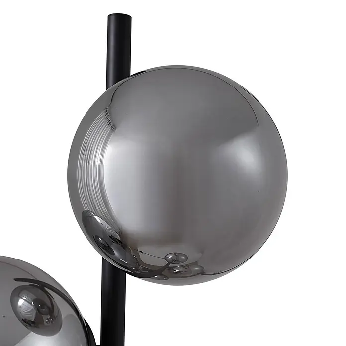 Lindby Stehlampe Wohnzimmer in schwarz, Stehleuchte -  - Nahaufnahme einer modernen Lampe mit rauchgrauen kugelförmigen Glasschirmen und einer schwarzen Metallstange.