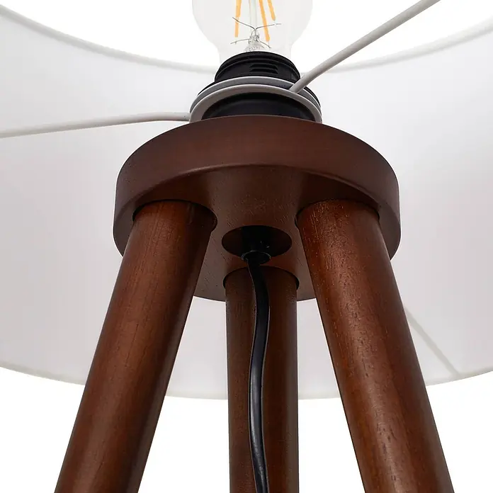 Lindby Stehlampe Wohnzimmer, Tripod in holz, weiß, Stehleuchte -  - Nahaufnahme eines dunkelbraunen Stativ-Stehleuchtenfußes aus Holz mit weißem Lampenschirmrahmen, Glühbirne und schwarzem Stromkabel.