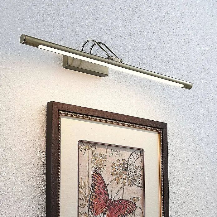Lindby LED Bilderleuchte in altmessing, Wandleuchte Bilderlampe -  - LED-Bilderleuchte in antikem Messing über einem gerahmten Kunstwerk an der Wand.