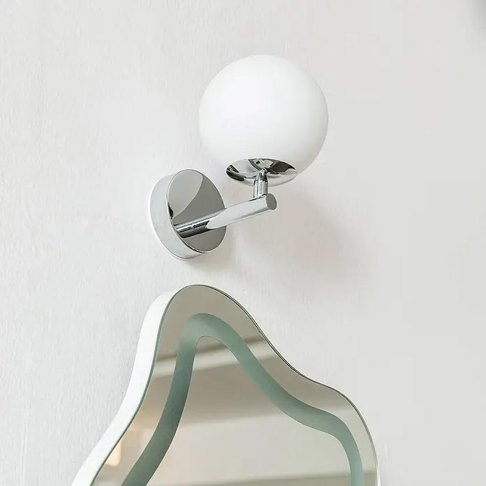 Arcchio LED Wandleuchte innen in chrom, weiß, Wandlampe -  - Verchromte Wandleuchte mit weißem Kugelschirm über einem Spiegel mit wellenförmiger Glaskante.