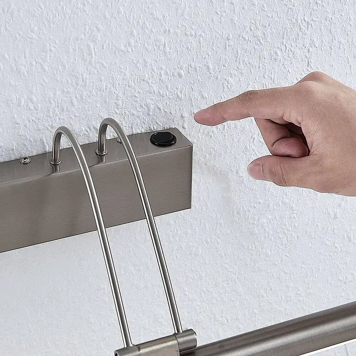 Lucande Bilderleuchte LED mit Schalter, Spiegelleuchte 69 cm -  - Eine Hand zeigt auf einen schwarzen Knopf an einer gebürsteten Nickel-Bilderleuchte. Die Leuchte hat zwei gebogene Arme.