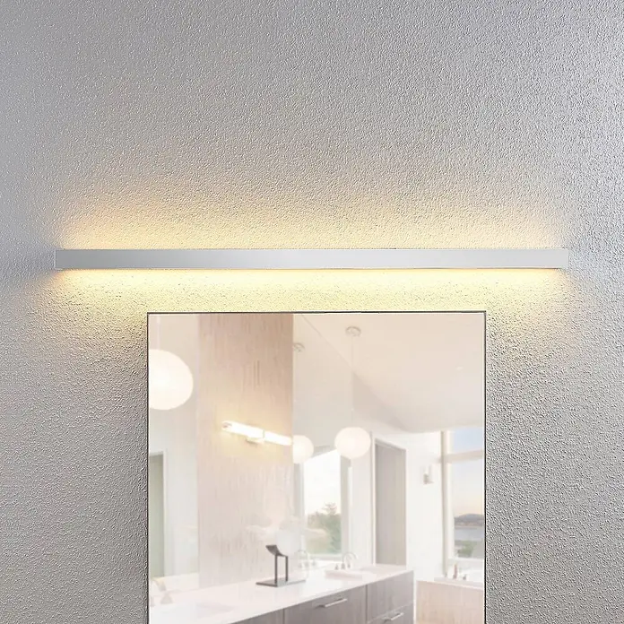 Lindby LED Wandleuchte innen in chrom, weiß, up down Wandlampe -  - Weiße, lineare LED-Spiegelleuchte, warmes Licht abstrahlend, über einem Badspiegel montiert.