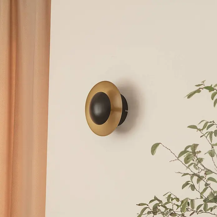 Lindby Wandleuchte Tiama - schwarz - Wandleuchte aus Messing und Schwarz, kugelförmig, an einer Wand im Innenbereich montiert.