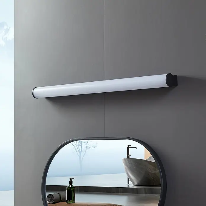 Lucande Wandleuchte Vilmara - schwarz - Lange weiße zylindrische Leuchte mit schwarzen Enden, horizontal über einem Spiegel in einem modernen Badezimmer montiert.