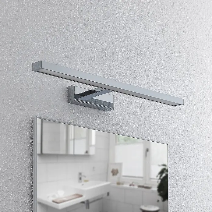 Lindby LED Wandleuchte innen in weiß, chrom, Wandlampe -  - Rechteckige LED-Spiegelleuchte in Chromoptik über einem Badezimmerspiegel montiert.