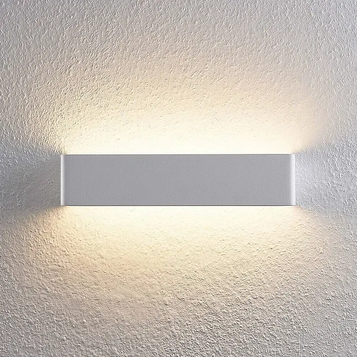 Arcchio LED Wandleuchte innen in weiß, Wandlampe -  - Rechteckige graue Wandleuchte mit warmem Up- und Downlight an strukturierter Wand.
