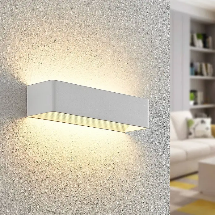 Arcchio LED Wandleuchte innen in weiß, Wandlampe -  - Weiße rechteckige Wandleuchte an einer strukturierten Wand, die warmes Licht nach oben und unten wirft.