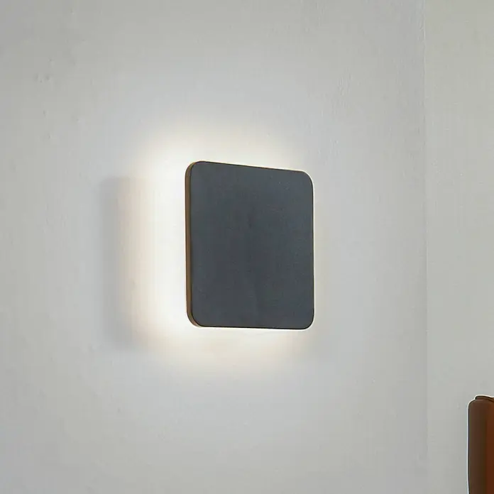 Lucande LED Wandleuchte innen in schwarz, Wandlampe -  - Dunkelgraue quadratische Wandleuchte mit abgerundeten Ecken, die die umliegende Wand sanft beleuchtet.