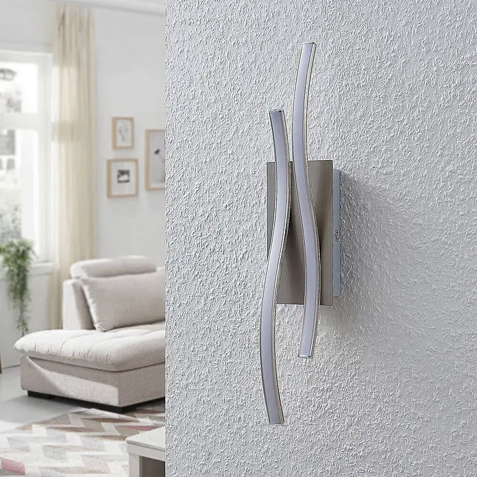 Lindby Wandleuchte Safia - alu / grau / zink, alu / grau / zink - Moderne Wandleuchte aus Metall mit zwei wellenförmigen, beleuchteten Streifen an einer strukturierten Wand.