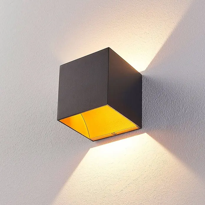 Arcchio LED Wandleuchte innen in schwarz, orange, Wandlampe -  - Anthrazitfarbene quadratische Wandleuchte mit goldener Innenseite, die warmes Licht nach oben und unten auf eine strukturierte Wand wirft.