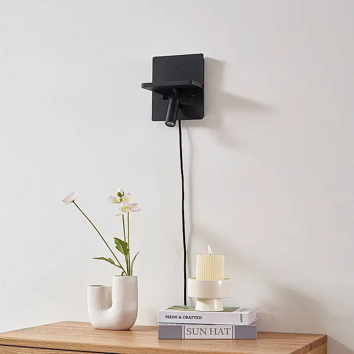 Lindby Wandleuchte Auden - schwarz, schwarz - Schwarzes Wandregal mit integriertem Strahler und USB-Ladeanschluss, über Holztisch montiert.