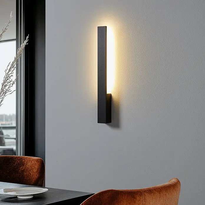Arcchio LED Wandleuchte innen in schwarz, Wandlampe -  - Moderne schwarze lineare Wandleuchte, die warmes Licht abstrahlt, an einer Wand in einem Raum montiert.