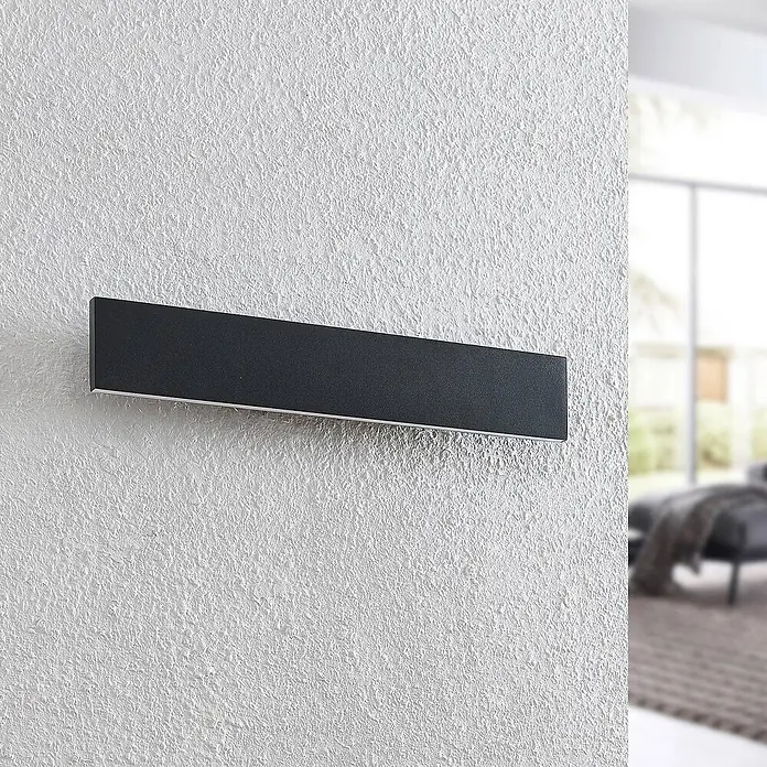 Lindby LED Wandleuchte innen in schwarz, up down Wandlampe -  - Rechteckige, dunkelgraue Wandleuchte mit silbernen Akzenten, montiert an einer strukturierten weißen Wand.