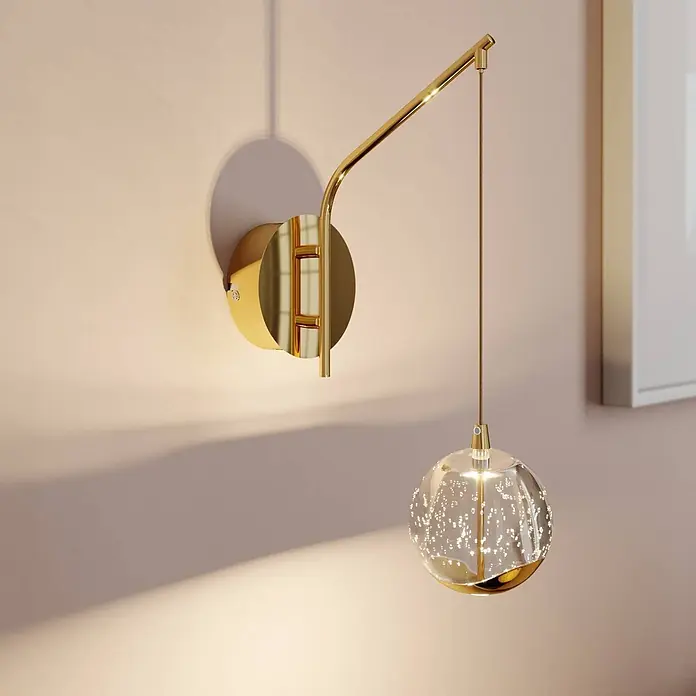 Lucande LED Wandleuchte innen in transparent, gold, Wandlampe -  - Goldene Wandleuchte mit gebogenem Arm und gläserner Kugelpendelleuchte mit internen Blasen, die warmes Licht wirft.