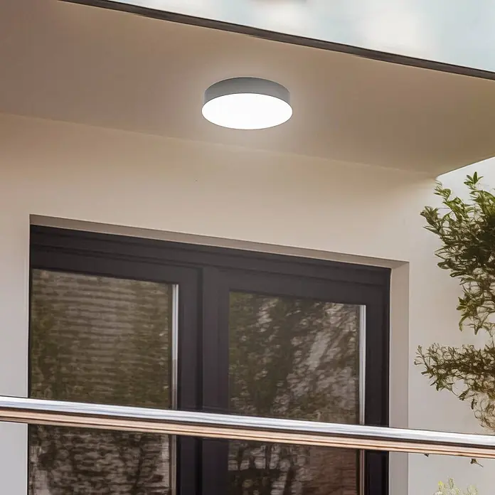 Lindby LED Outdoor Deckenlampe in anthrazit, weiß, mit Bewegungsmelder, -  - Runde graue Deckenleuchte mit weißem Diffusor, an einer Außendecke montiert, spendet helles Licht.