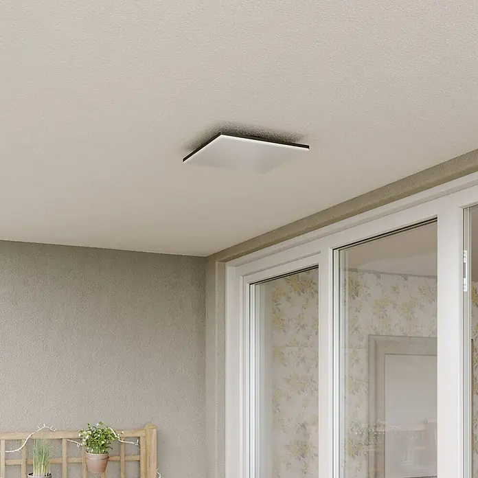 Lucande Außenwand- & Deckenleuchte Henni - alu / grau / zink, IP65 - Eine moderne, quadratische weiße Deckenleuchte mit dunklem Rand an einer strukturierten Decke, die einen Außenbereich beleuchtet.