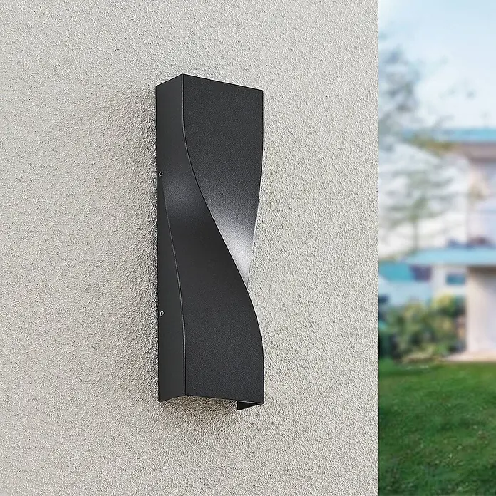 Lucande LED Wandleuchte aussen in anthrazit, Aussenlampe Wand -  - Dunkelgraue Außenwandleuchte mit gedrehtem, modernem Design an einer strukturierten Wand.