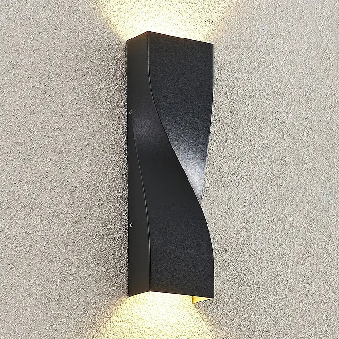 Lucande LED Wandleuchte aussen in anthrazit, Aussenlampe Wand -  - Schwarze, skulpturale Up-Down-Wandleuchte mit verdrehtem Design, an einer strukturierten Wand montiert.