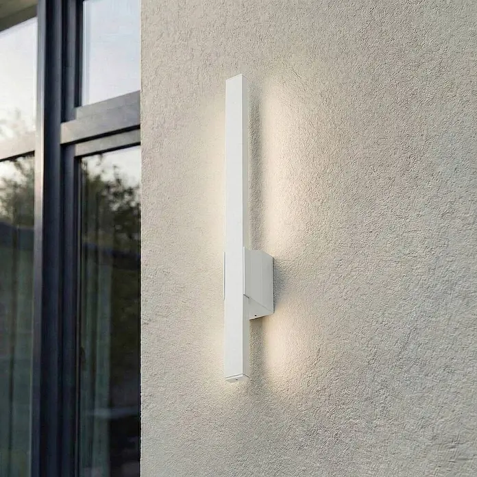 Lindby LED Wandleuchte aussen in weiß, Aussenlampe Wand -  - Weiße, rechteckige Außenwandleuchte an texturierter Wand, die Licht nach oben und unten wirft.