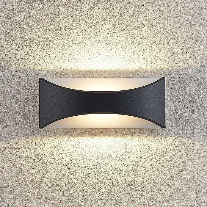Lindby LED Wandleuchte aussen in anthrazit, weiß, Aussenlampe Wand -  - Eine dunkelgraue, rechteckige Wandleuchte mit gebogenen Seiten, die warmes Licht nach oben und unten auf eine strukturierte Wand wirft.