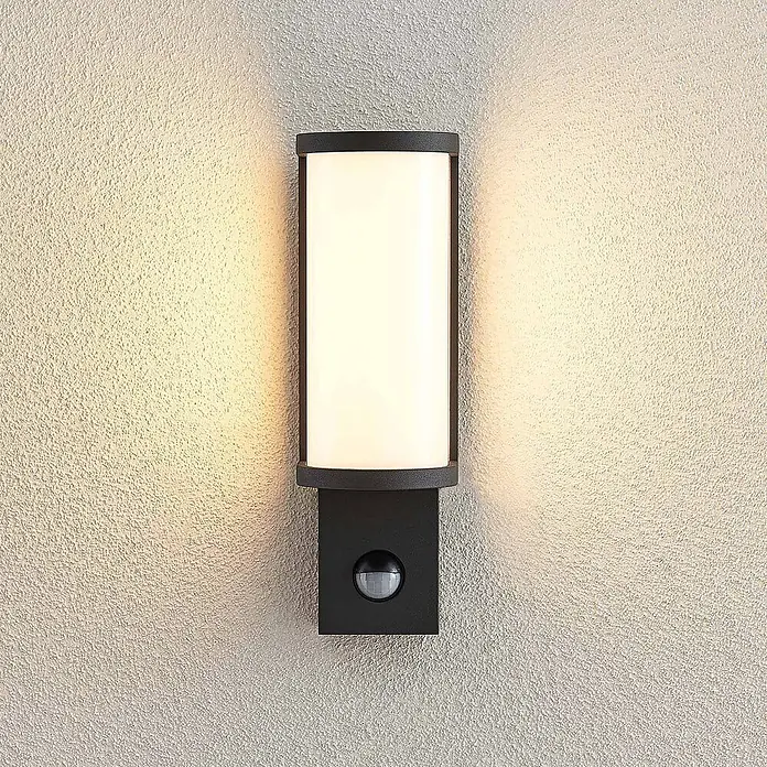 Lucande LED Wandleuchte aussen in graphit, weiß, mit Bewegungsmelder, -  - Anthrazitfarbene Außenwandleuchte mit rechteckiger Lichtfläche und Bewegungsmelder, spendet warmes Licht an strukturierter Wand.