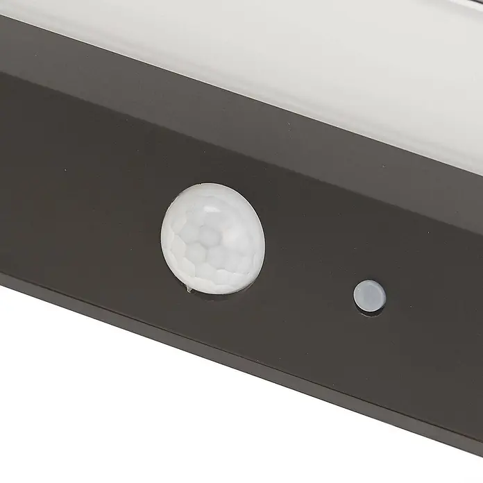 Lindby Außenwandleuchte Maresia - alu / grau / zink, IP44 - Dunkelbraune Sensoreinheit mit weißer Bewegungssensorkuppel und kleinem Lichtsensor.