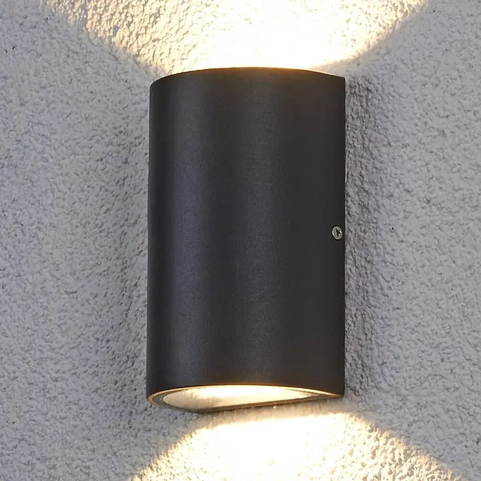 Lucande LED Wandleuchte aussen in anthrazit, transparent, Aussenlampe Wand -  - Dunkelgraue Metall-Wandleuchte, nach oben und unten leuchtend, an einer strukturierten Wand montiert.