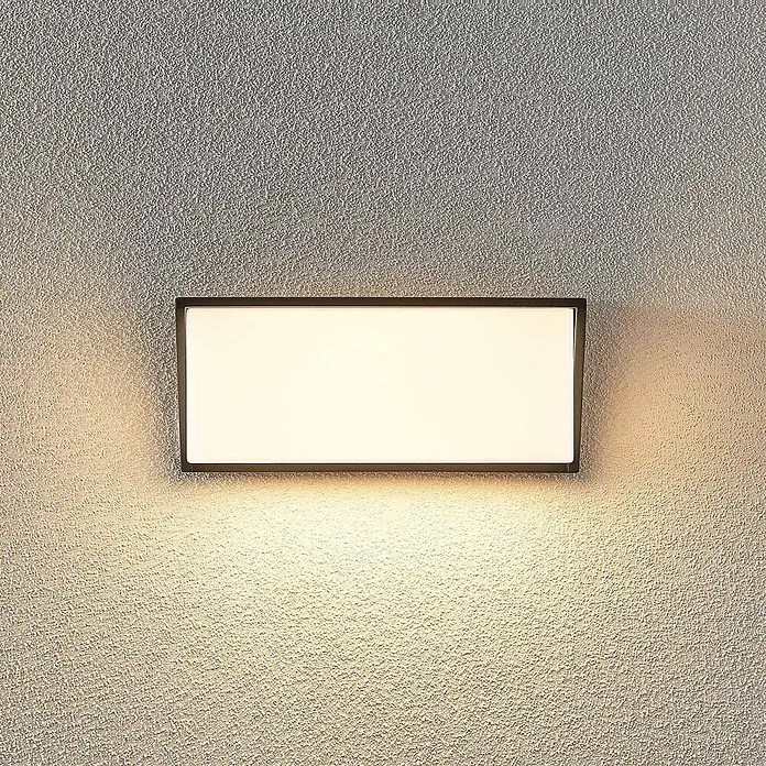 Lindby LED Wandleuchte aussen in anthrazit, weiß, Aussenlampe Wand -  - Rechteckige Wandleuchte mit dunklem Rahmen und weißem Diffusor, wirft warmes Licht auf eine strukturierte Wand.