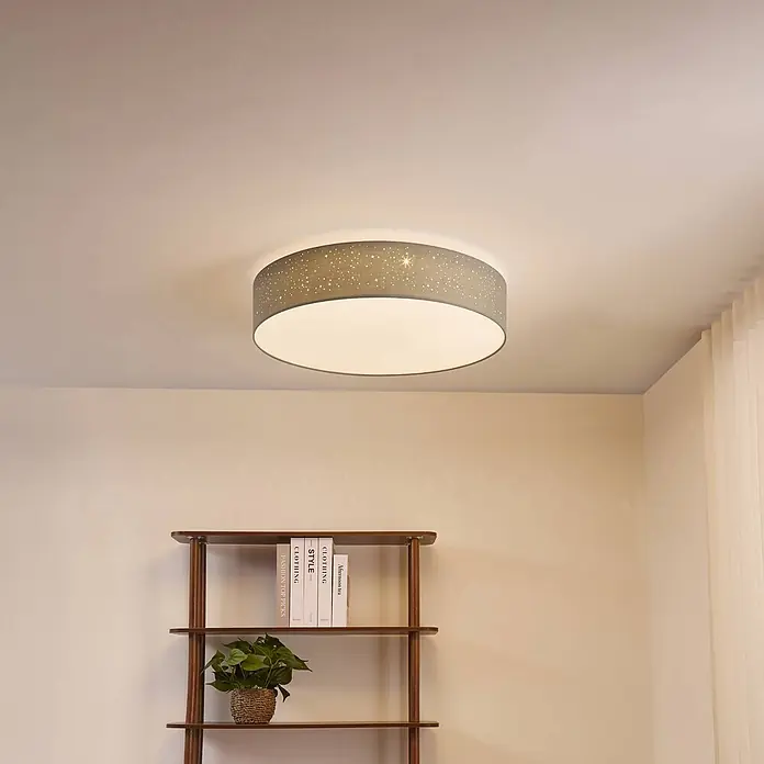 Lindby Deckenleuchte Ellamina - alu / grau / zink - Eine runde Deckenleuchte aus grauem Stoff mit Sternmustern beleuchtet einen Raum.