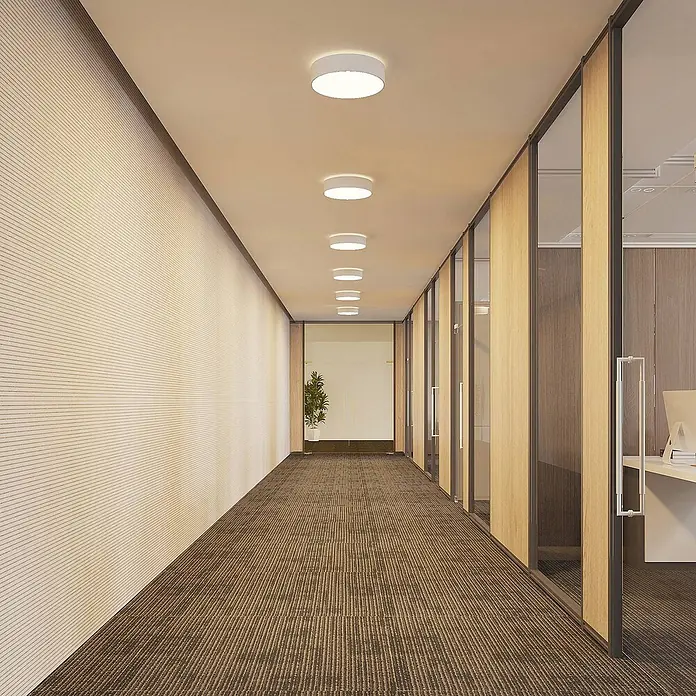 Arcchio LED Deckenlampe in weiß, Deckenleuchte rund -  - Weiße runde Deckenleuchten beleuchten einen modernen Büroflur mit gestreiftem Teppich und Glaswänden.