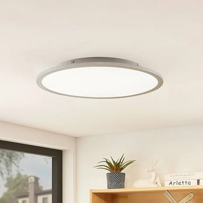 Lindby LED Deckenlampe in silber, Deckenleuchte rund -  - Eine runde, flache LED-Deckenleuchte mit silbergrauem Rand, bündig an einer hellen Decke in einem modernen Raum montiert.