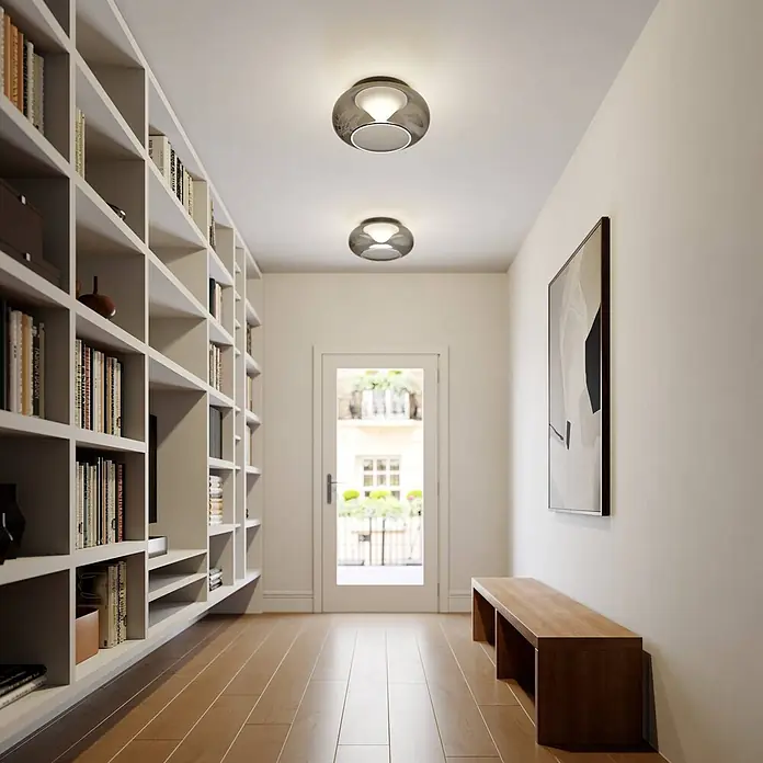Lucande Deckenleuchte Mijo - alu / grau / zink - Zwei runde Deckenleuchten aus Rauchglas beleuchten einen modernen Flur mit Holzboden und Einbauregal.