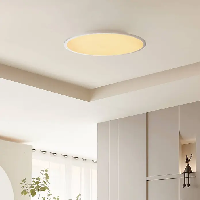 Lindby LED Deckenlampe in weiß, silber, Deckenleuchte rund -  - Eine runde, flache Deckenleuchte mit weißem Rahmen spendet ein warmes Licht in einem modernen Raumambiente.