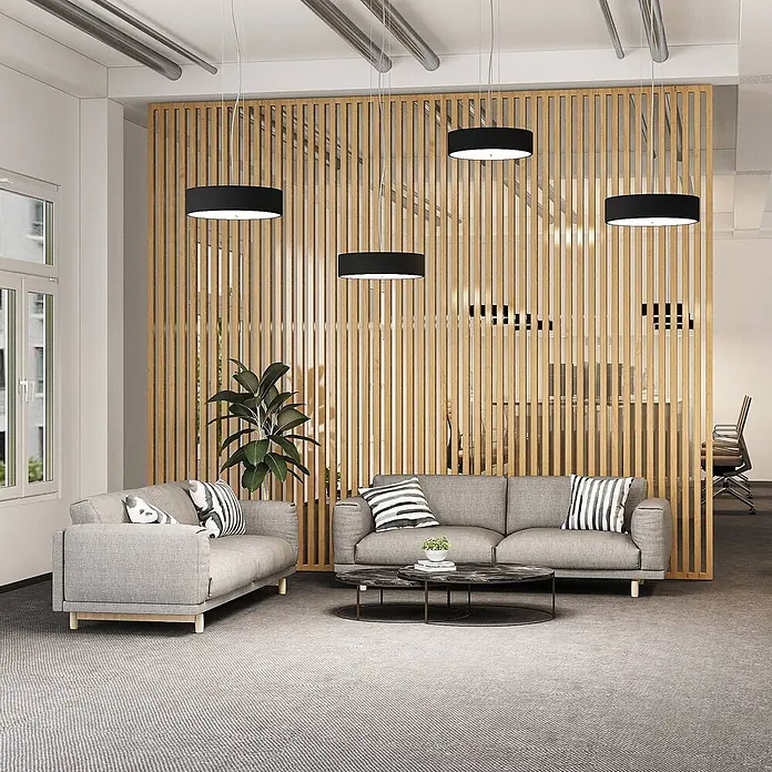 Arcchio LED Pendelleuchte in schwarz, weiß, up down Hängelampe -  - Vier schwarze zylindrische Pendelleuchten, die in einem modernen Loungebereich von der Decke hängen.