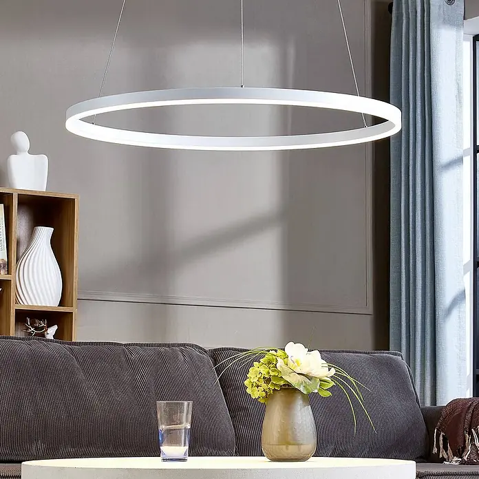 Arcchio LED Pendelleuchte in weiß, Hängelampe -  - Schlanke, weiße kreisförmige LED-Pendelleuchte hängt von der Decke und beleuchtet ein modernes Wohnzimmer.