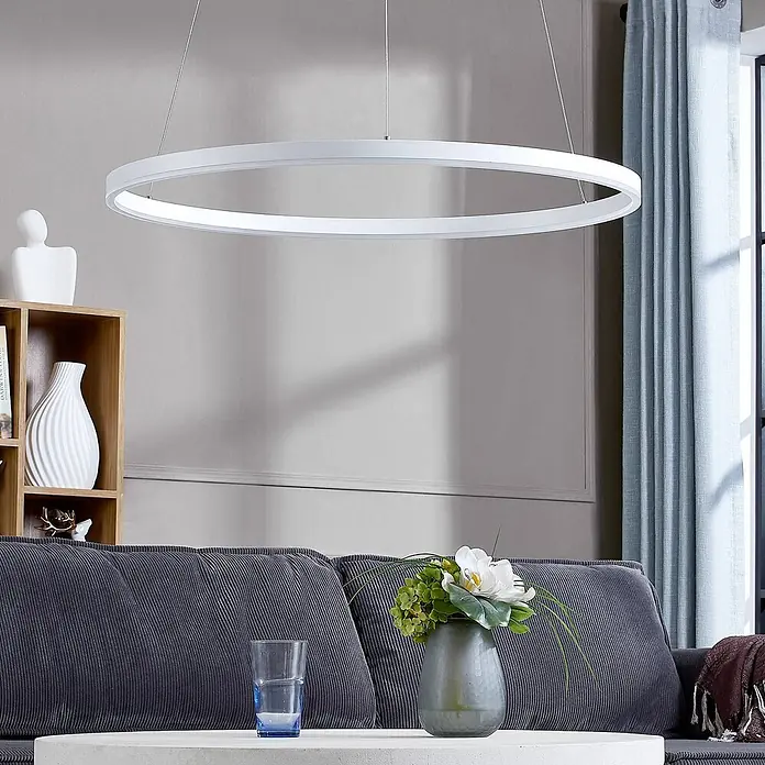 Arcchio LED Pendelleuchte in weiß, Hängelampe -  - Eine weiße kreisförmige LED-Pendelleuchte hängt von der Decke und beleuchtet ein modernes Wohnzimmer.