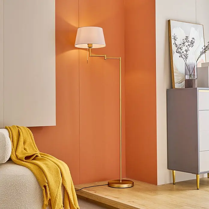 Lindby Stehlampe Wohnzimmer in bronze, weiß, up down Stehleuchte -  - Goldfarbene Stehlampe mit verstellbarem Arm und weißem Stoffschirm, beleuchtet einen Raum.