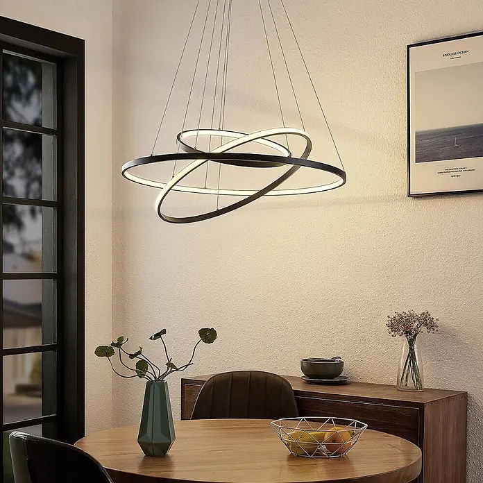 Lucande LED Pendelleuchte in schwarz matt, Hängelampe -  - Moderne schwarze LED-Deckenleuchte mit ineinander verschlungenen Ringen über einem Esstisch.
