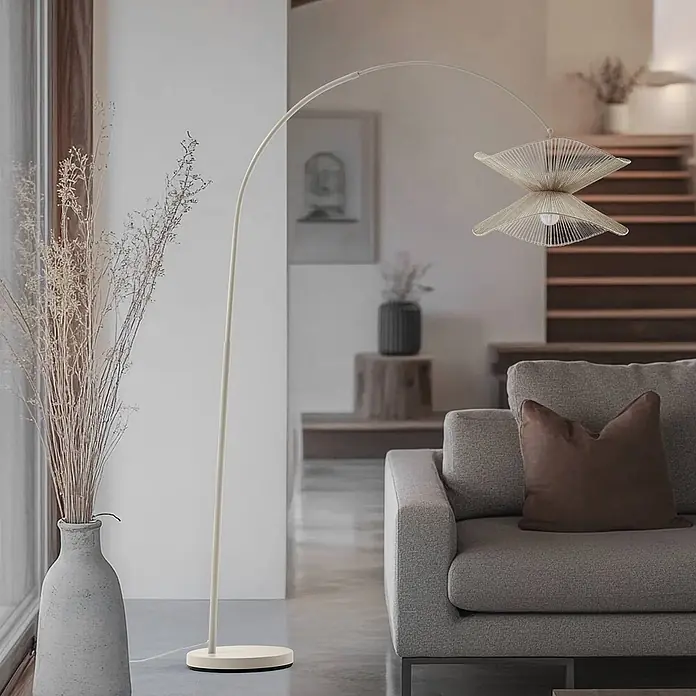 Lindby Stehleuchte Valdorin - creme / amber, creme / amber, E27 - Bogenlampe mit hellem, mehrlagigem Fadenschirm beleuchtet ein modernes Wohnzimmer.