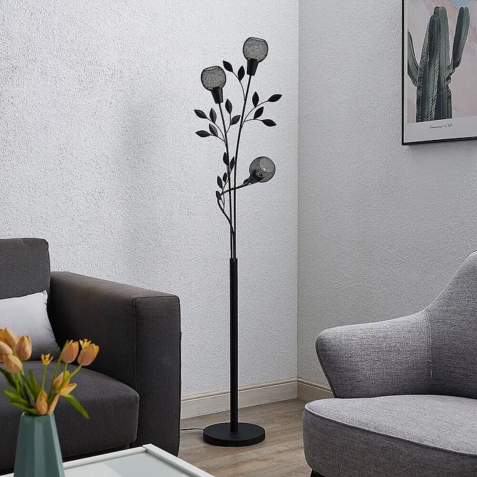 Lindby Stehlampe Wohnzimmer in schwarz, Stehleuchte -  - Schwarze baumartige Stehlampe mit drei netzverkleideten Lichtern, zwischen zwei Sofas im Wohnzimmer.