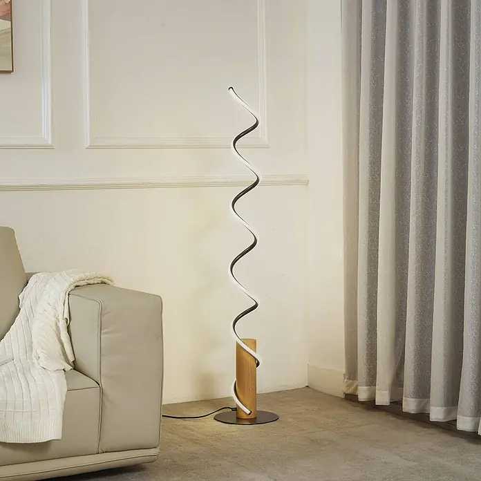 Lindby LED Stehlampe Wohnzimmer in grau, holz, Stehleuchte -  - Moderne Spiral-LED-Stehlampe mit hellem Holzzylinderfuß und schwarzem Metallständer, die ein Wohnzimmer beleuchtet.