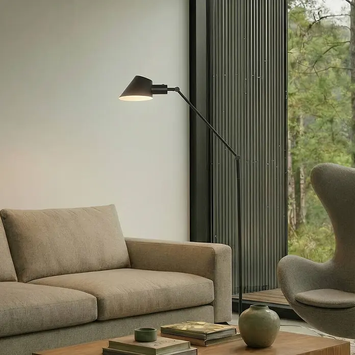 Lindby Stehlampe Wohnzimmer in schwarz, Stehleuchte -  - Schwarze Metall-Stehlampe beleuchtet ein modernes Wohnzimmer mit beigefarbenem Sofa und grauem Sessel.