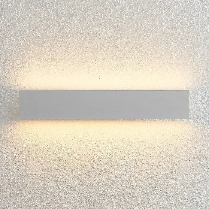 Lindby LED Wandleuchte innen in weiß, up down Wandlampe -  - Rechteckige grau-silberne Wandleuchte an einer strukturierten weißen Wand, die warmes Ober- und Unterlicht wirft.